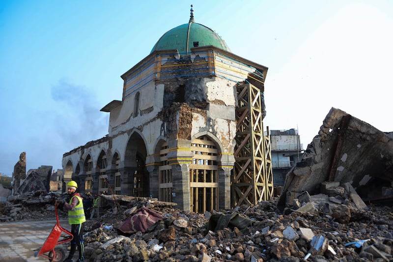 An Iraqi worker clears rubble during the reconstruction of the Great Mosque of Al-Nuri in Mosul’s war-ravaged old town, on December 15, 2019. The famed complex including the 12th century mosque and its 8th century leaning minaret dubbed "Al-Hadba" or "the hunchback", was where the chief of the Islamic State group Abu Bakr al-Baghdadi declared a self-styled "caliphate" after sweeping into Mosul in 2014. It was ravaged three years later in the final, most brutal stages of the months-long fight against IS, before rebuilding works started in mid-December 2018. / AFP / Zaid AL-OBEIDI
