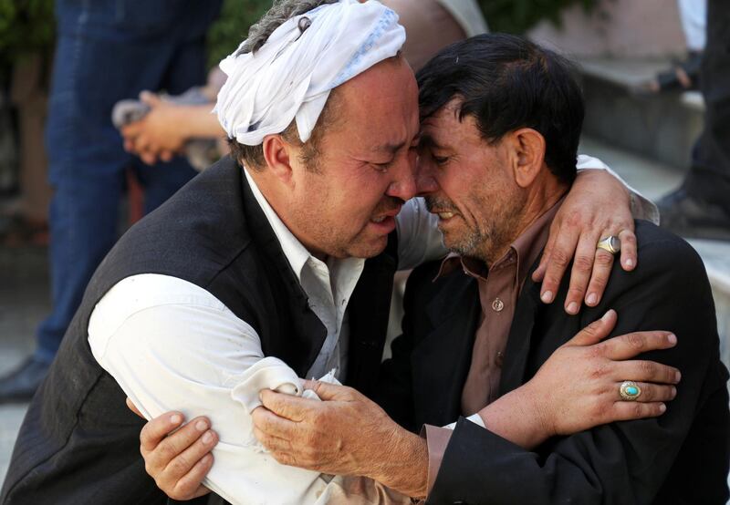 Afghan men mourn during the funeral of their relatives after a wedding suicide bomb blast in Kabul, Afghanistan August 18, 2019. REUTERS/Omar Sobhani