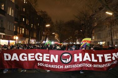 People hold a banner while attending a vigil for the victims of a shooting by a far-right extremist that left several people dead in Hanau, near Frankfurt, Germany. REUTERS/Christian Mang