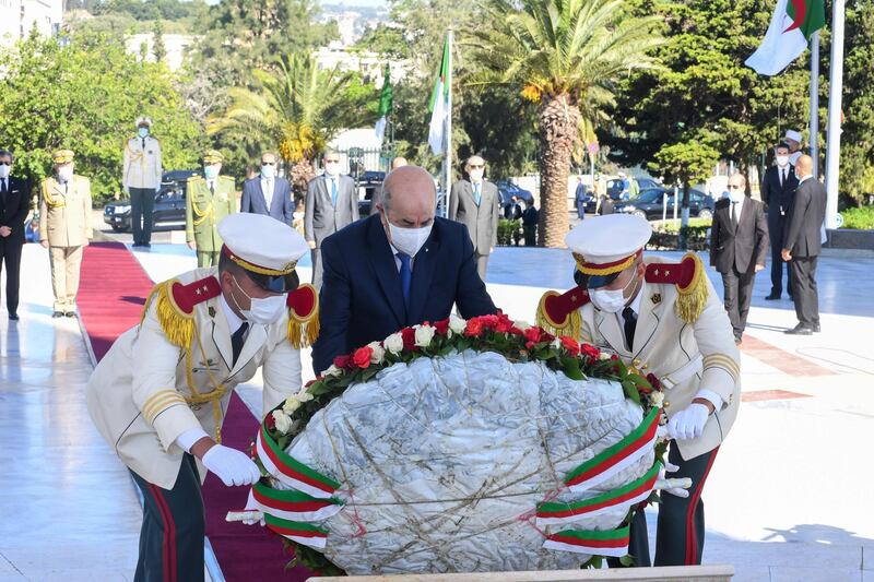 Algeria's President Abdelmajid Tebboune lays a wreath during a ceremony to lay to rest the remains of 24 resistance fighters. AFP