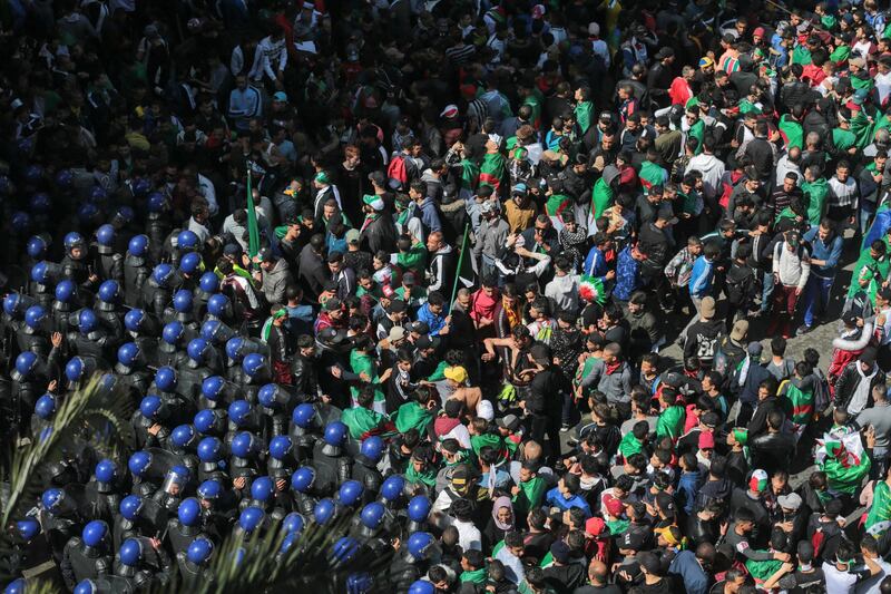 Protesters confront police officers during a demonstration against the country's leadership, in Algiers, Friday, April 12, 2019. Heavy police deployment and repeated volleys of water cannon and tear gas didn't deter masses of Algerians from packing the streets of the capital Friday, insisting that their revolution isn't over just because the president stepped down. (AP Photo/Mosa'ab Elshamy)