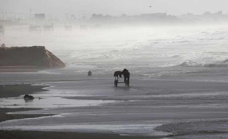 A Palestinian hawker wheels his wares across the beach in Gaza City. AP Photo