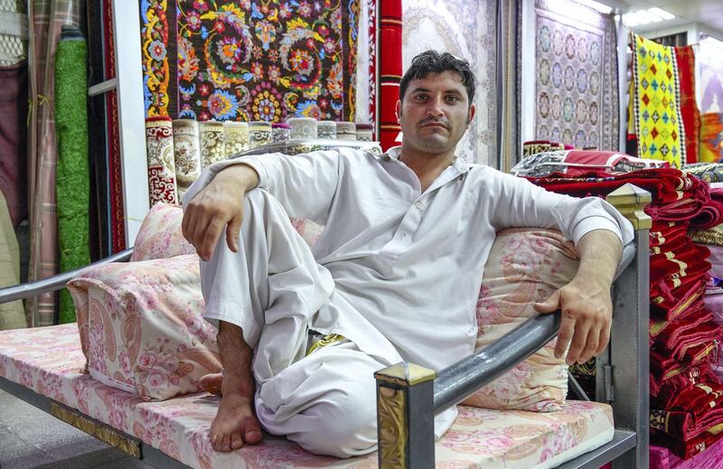 Abu Dhabi, United Arab Emirates, July 17, 2019.  Vendors of Al Mina Photo Project.  Al Mina Souk Market --  Carpet vendor, Ali Ahmad-25 from Pakistan.
Victor Besa/The National
Section:  NA
Reporter: