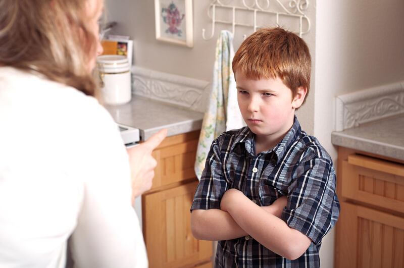 A mother scolds her angry son.