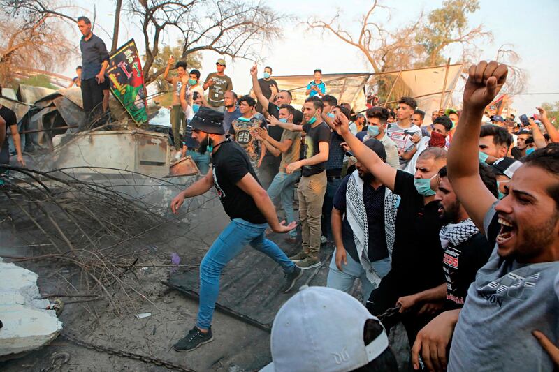 Protesters pull down concrete walls outside the governor's building in Basra. AP Photo