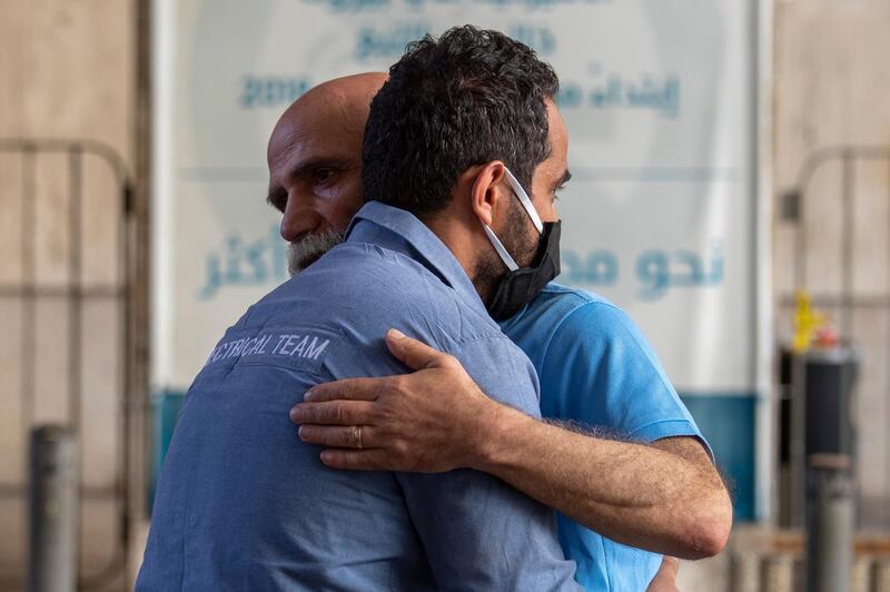 Lebanese former employees of the American University Medical Centre comfort each other after they were dismissed from their jobs outside the hospital after in Beirut. AP