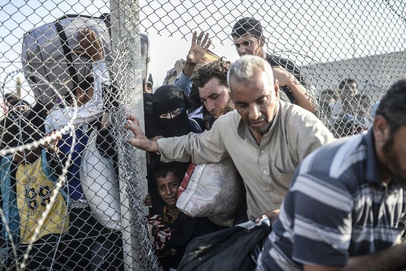 Some squeezed under the mesh-wire barrier. Bulent Kilic/AFP Photo