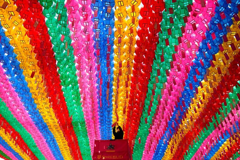 In Seoul, South Korea, a worker attaches prayer petitions for the upcoming birthday of Buddha. Reuters