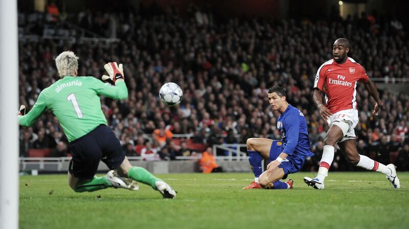 Manchester United's Portuguese midfielder Cristiano Ronaldo (R) scores his second goal past Arsenal's Spanish goalkeeper Manuel Almunia (L) during their UEFA Champions League semi final 2nd leg football match against Arsenal at the Emirates Stadium, North London, England, on May 5, 2009. AFP PHOTO/CARL DE SOUZA (Photo by CARL DE SOUZA / AFP)