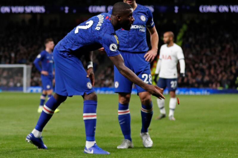 Chelsea's German defender Antonio Rudiger throws an object off the playing surface during the English Premier League football match between Tottenham Hotspur and Chelsea at Tottenham Hotspur Stadium in London, on December 22, 2019. (Photo by Adrian DENNIS / AFP) / RESTRICTED TO EDITORIAL USE. No use with unauthorized audio, video, data, fixture lists, club/league logos or 'live' services. Online in-match use limited to 120 images. An additional 40 images may be used in extra time. No video emulation. Social media in-match use limited to 120 images. An additional 40 images may be used in extra time. No use in betting publications, games or single club/league/player publications. / 