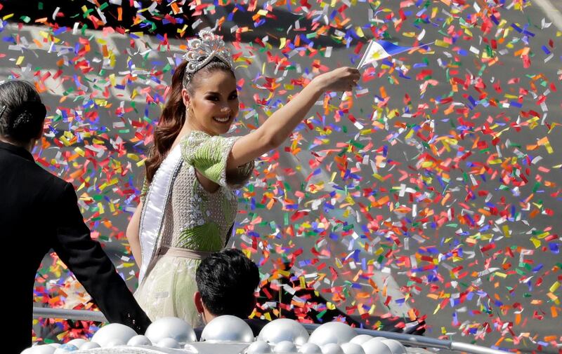 Confetti rains on new Miss Universe 2018 Catriona Gray as she waves a Philippine flag during her homecoming motorcade around Manila, Thursday, Feb. 21, 2019, in the Philippines. Gray, the Fourth Filipino to win the Miss Universe, is here for a grand homecoming, two months after winning the crown in Bangkok, Thailand. (AP Photo/Bullit Marquez)