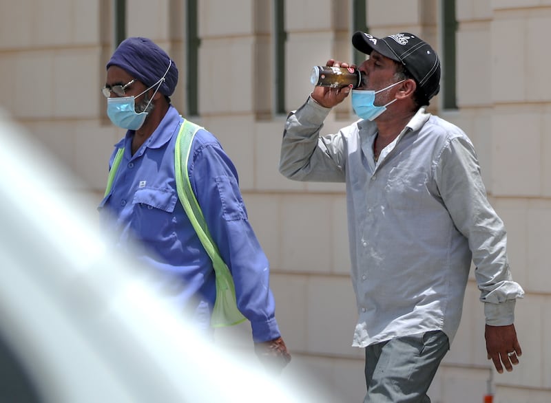 A worker hydrates after a hot day. All photos: Victor Besa / The National