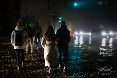 Residents walk through an unlit street following missile strikes on November 24 in Kyiv, Ukraine. Getty Images