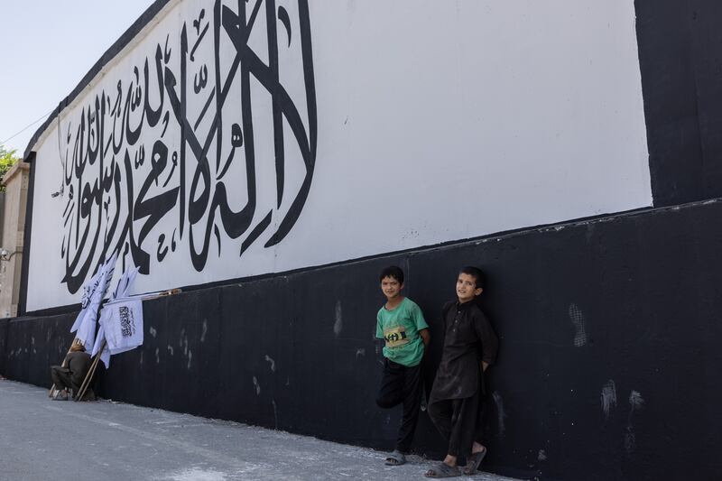 Children stand outside the former US embassy in Kabul where the banner of the 'Islamic Emirate' has replaced previous murals, on September 8, 2021. Stefanie Glinski for The National