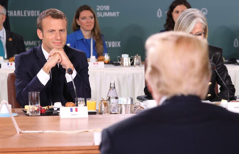 French President Emmanuel Macron looks at US President Donald Trump at the Gender Equality Advisory Council meeting on June 9, 2018. EPA