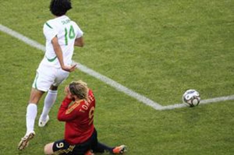 Spain's Fernando Torres loses out in a tackle against Iraq.