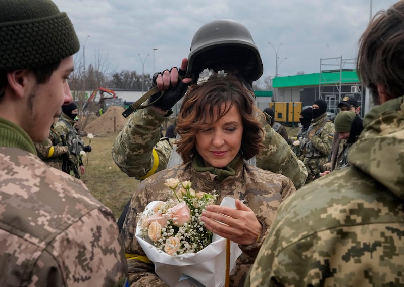 A soldier holds a helmet as a wedding crown during the ceremony for members of the Ukrainian Territorial Defence Forces Lesia Ivashchenko and Valerii Fylymonov, at a checkpoint in Kyiv. AP