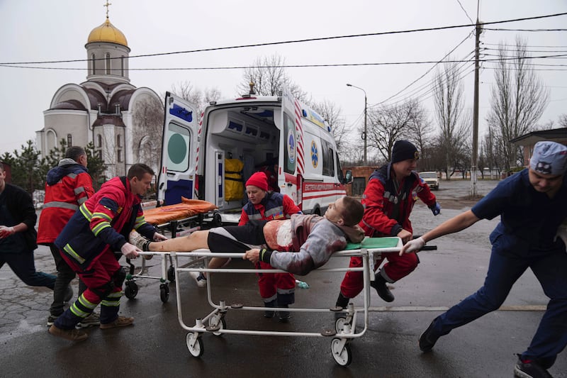 Paramedics move a man who was wounded by shelling in a residential area of Mariupol, south-eastern Ukraine. AP