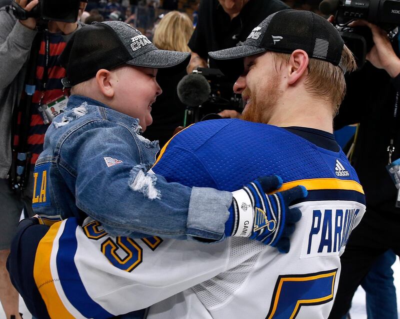 St. Louis Blues Colton Parayko lifts young fan Laila Anderson, left, while the team celebrated on the ice after the Blues defeated the Boston Bruins in Game 7 of the NHL Stanley Cup Final in Boston. AP Photo