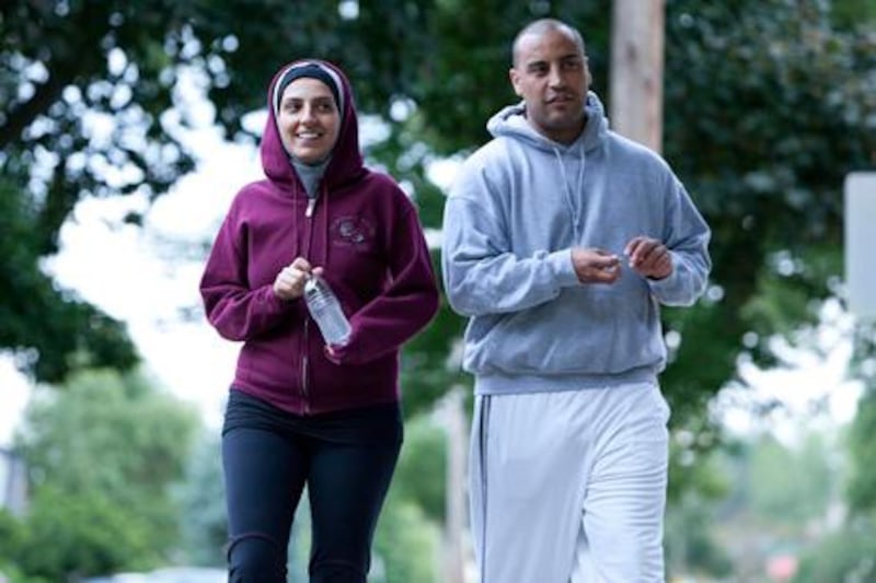 Nawal Aoude, a paediatric respiratory therapist, left, and her husband Nader go for a walk in a scene from the TLC series All-American Muslim. Adam Rose / Discovery, AP Photo