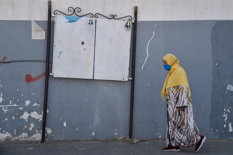 A woman walks past an empty billboard, ahead of the constitutional referendum, in the capital Algiers, Algeria. AFP