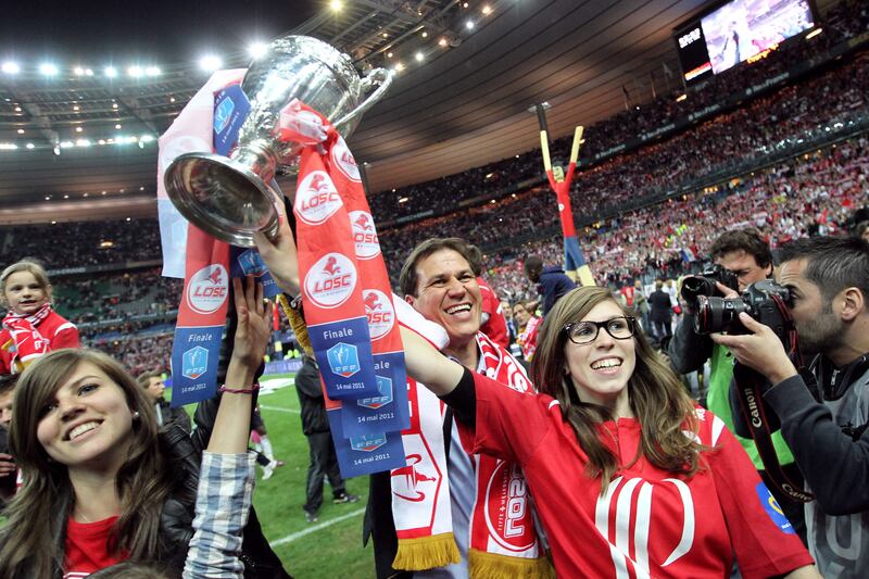 Lille's French coach Rudi Garcia celebrates with his daughters and the trophy at the end of the French Cup final against PSG on May 14, 2011, at the Stade de France in Saint-Denis, northern Paris. Lille won 1-0. AFP