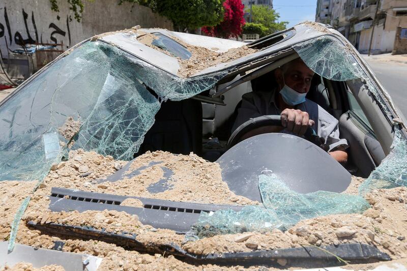 A Palestinian man drives his car, which was damaged in an Israeli air strike, to a repair workshop in Gaza city. Reuters