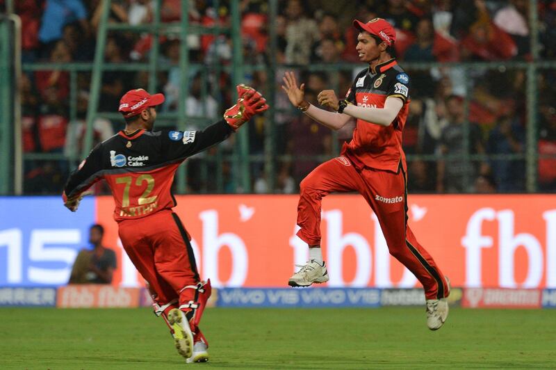 Royal Challengers Bangalore fielder Navdeep Saini (R) celebrates with wicket keeper Parthiv Patel the dismissal of Mumbai Indians batsman Krunal Pandya during the 2019 Indian Premier League (IPL) Twenty20 cricket match between Royal Challengers Bangalore and Mumbai Indians at The M. Chinnaswamy Stadium in Bangalore on March 28, 2019. (Photo by Manjunath KIRAN / AFP) / IMAGE RESTRICTED TO EDITORIAL USE - STRICTLY NO COMMERCIAL USE