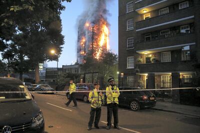 (FILES) In this file photo taken on June 14, 2017 police man a security cordon as a huge fire engulfs the Grenfell Tower early June 14, 2017 in west London.  In the early hours of June 14, 2017, Kerry O'Hara, a sixth-floor resident in Grenfell Tower, an apartment block in west London, was preparing to go to bed when she smelled burning. - TO GO WITH AFP STORY by JOE JACKSON
 / AFP / Daniel LEAL-OLIVAS / TO GO WITH AFP STORY by JOE JACKSON
