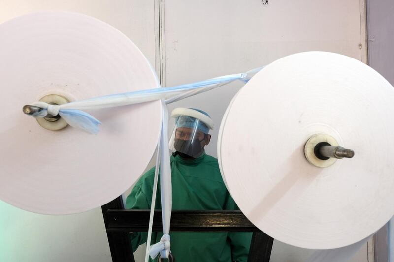 Rolls of fabric feed into a machine on a protective mask production line at Central Reserve Police Force (CRPF) Northern Sector staff camp in New Delhi, India. Bloomberg