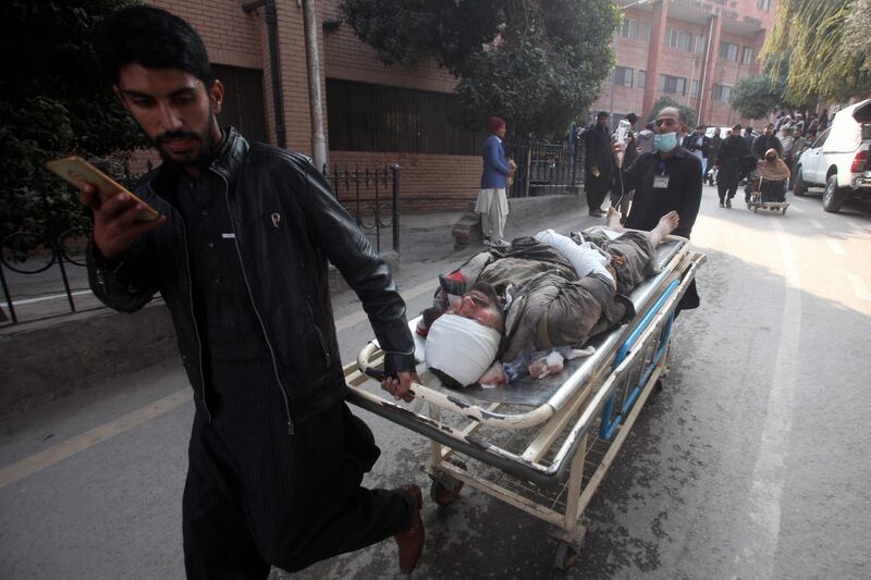 People rush a wounded man to hospital. AFP