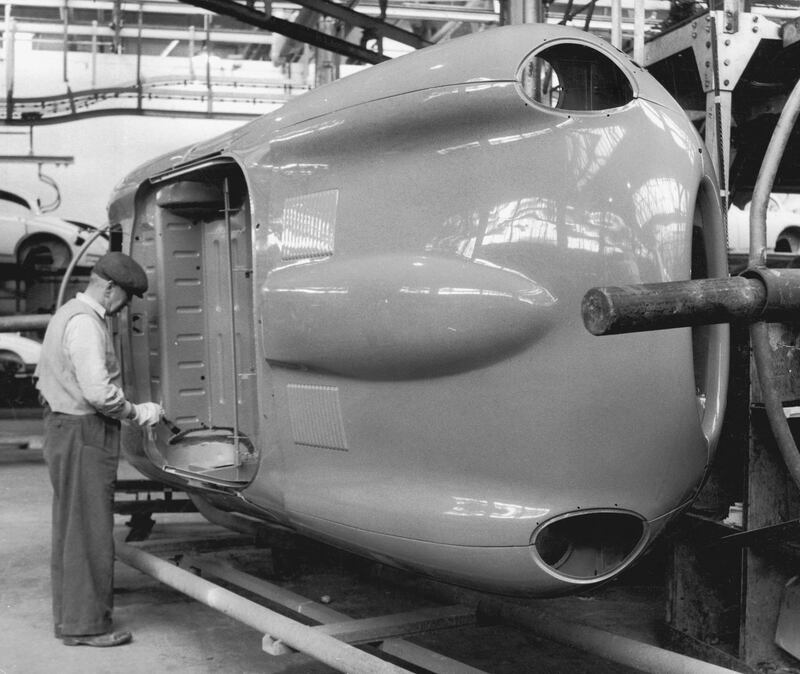 A worker touches up the paintwork on an E-Type Jaguar body shell at the company's Coventry works, 25th May 1961. (Photo by Chris Ware/Keystone Features/Hulton Archive/Getty Images)