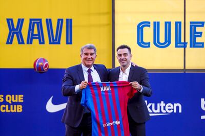 Xavi Hernandez poses next to Barcelona president Joan Laporta. AP