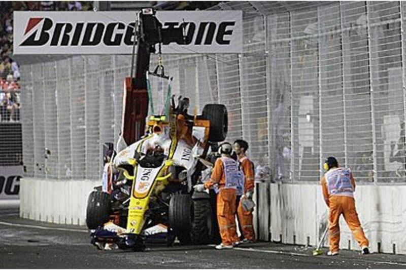 Track marshals recover the crashed Renault car of Nelson Piquet Jr during the 2008 Singapore Grand Prix.