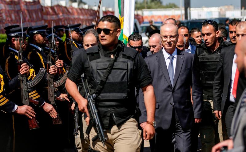 Palestinian Prime Minister Rami Hamdallah (second right), escorted by his bodyguards, is greeted by police forces of Hamas (left)  upon his arrival in Gaza City on March 13, 2018. Mahmud Hams / AFP