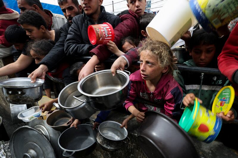 Palestinians in Rafah wait to receive food from a charity. Reuters