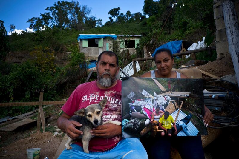 William Fontan Quintero and his wife Yadira Sostre pose with a printed photo of them taken on September 30, 2017, when they sat amid the rubble of their home destroyed by Hurricane Maria. "We don't have time to build anything safe without help," said Quintero.