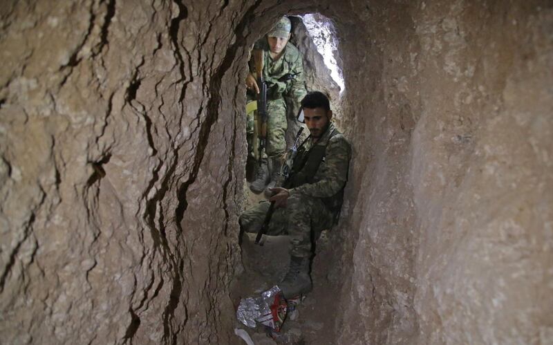 Turkish-backed Syrian fighters inspect a tunnel, said to have been built by Kurdish fighters, in the Syrian border town of Tal Abyad. AFP