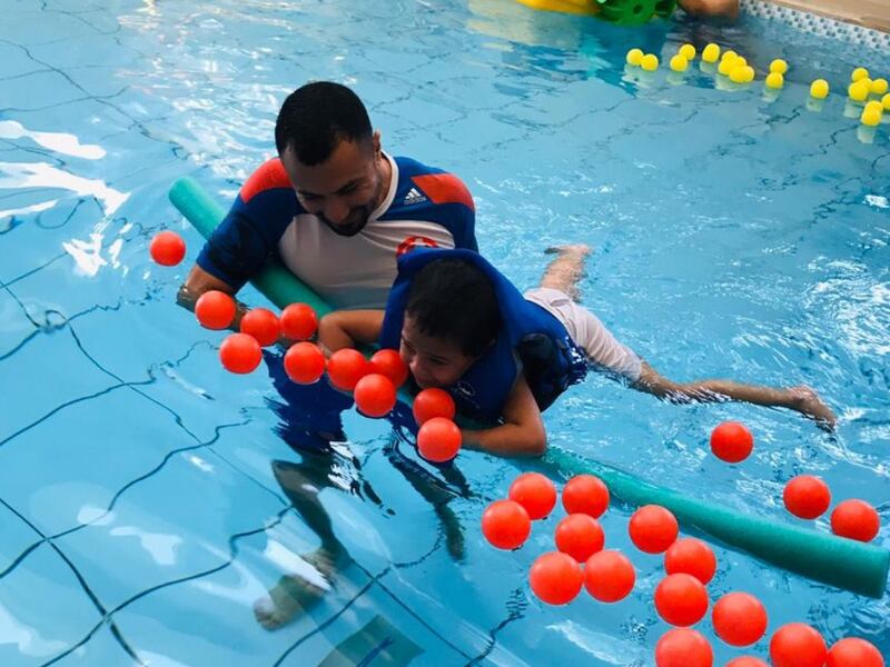 Riadh Zammali, the global teacher prize nominee helps a young child with her swimming. Photo: Riadh Zammali