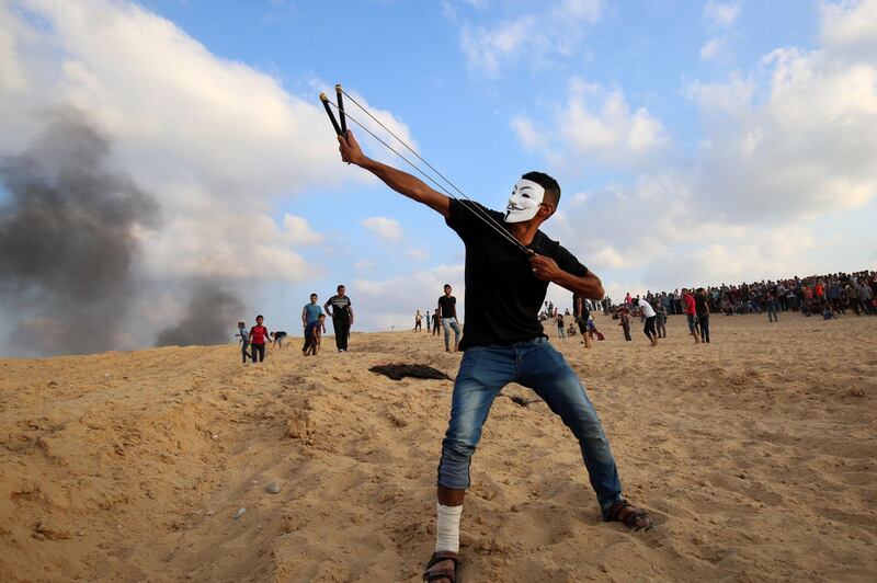 Palestinian protesters use slingshots at a demonstration on the beach near the maritime border with Israel, in the northern Gaza Strip. Said Khatib/AFP