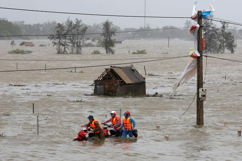 People recover motorbikes from a flooded field while the Doksuri storm hits in Ha Tinh province, Vietnam. Kham / Reuters