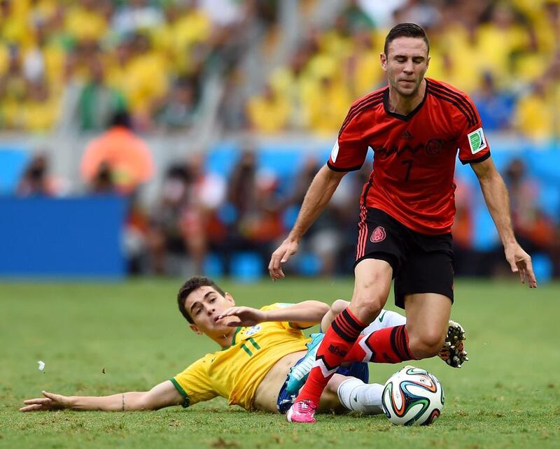 Oscar of Brazil tackles Miguel Layun of Mexico during their match on Tuesday at the 2014 World Cup in Fortaleza, Brazil. Buda Mendes / Getty Images