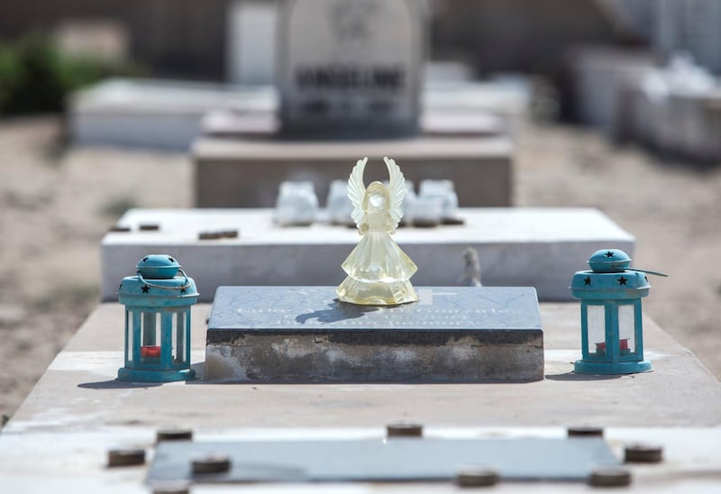 ABU DHABI, UNITED ARAB EMIRATES - A souvenir angel left by a family member at a tomb at Sas Al Nakhel Cemetery, Non Muslim.  Ruel Pableo for The National for John Dennehy's story