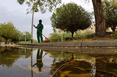 A worker in Dubai cleaning the garden area in the low-lying Gardens community. Pawan Singh/The National