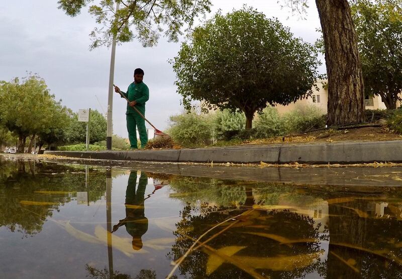 A man cleaning the garden area at the Gardens in Dubai after the rain. Pawan Singh/The National