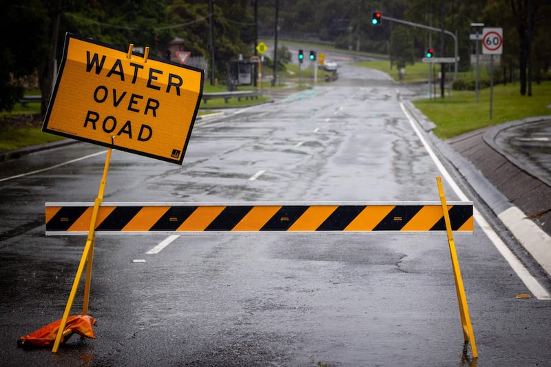 A closed road sign at the flooded Bulimba Creek at Cannon Hill. AFP