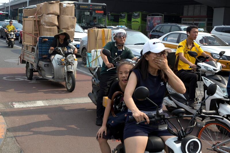 A delivery man transports goods on the streets of Beijing, China, Friday, July 6, 2018. The United States hiked tariffs on Chinese imports Friday and Beijing said it immediately retaliated in a dispute between the world's two biggest economies that President Donald Trump says he is prepared to escalate. (AP Photo/Ng Han Guan)