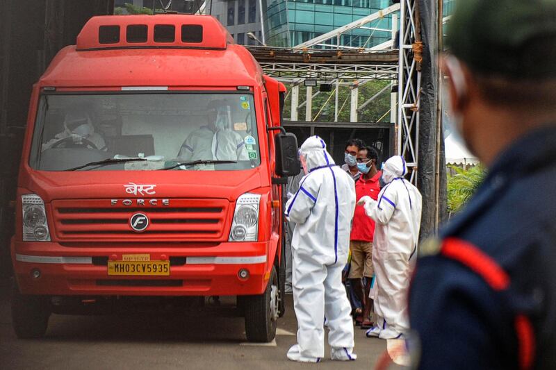 Medical staff wearing personal protective equipment oversee Covid-19 patients boarding an ambulance as they are shifted from a field hospital to a another centre ahead of a cyclonic storm that may hit the north Maharashtra and Gujarat coast, in Mumbai.  AFP