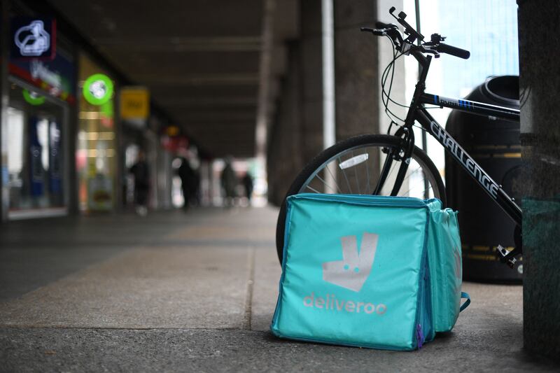A Deliveroo bag and bike are parked near Victoria Station in central London. The group said it benefited from further strength in its key UK business, where orders increased by 72 per cent. AFP