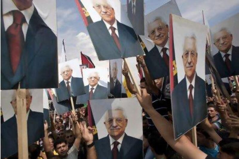 Palestinians hold pictures of President Mahmoud Abbas in the West Bank city of Ramallah as he received received a hero's welcome in the West Bank. Bernat Armangue / AP Photo